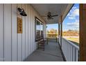 Charming covered front porch features ceiling fan, sconce lighting, and wooden benches to relax and unwind at 3694 Nc-62 N Hwy, Burlington, NC 27217