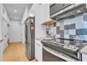 Modern kitchen featuring stainless steel appliances and a checkered backsplash at 521 N Mangum St # 12, Durham, NC 27701
