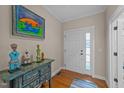 Bright foyer featuring hardwood floors, console table, and beautiful artwork at 5213 Orabelle Ct, Raleigh, NC 27606