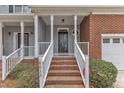 Charming entryway with brick steps, white railings, and a stylish front door with a transom window at 6013 Kohler Ln, Raleigh, NC 27616