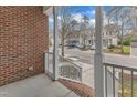 Relaxing view of the neighborhood street from the covered front porch with white railing and brick base at 6013 Kohler Ln, Raleigh, NC 27616