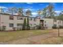A light brown residential building with mature trees and a manicured lawn on a partly cloudy day at 612 Pine Ridge Pl, Raleigh, NC 27609