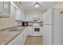 Bright kitchen featuring white cabinetry, modern appliances, double stainless-steel sink and neutral countertops at 612 Pine Ridge Pl, Raleigh, NC 27609