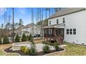 A large backyard featuring a patio, fire pit, screened porch, and wooded area at 8816 Knights Union Way, Wake Forest, NC 27587