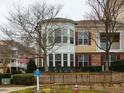 Townhouse with brick accents, well-maintained landscaping, and community sign at 9221 Calabria Dr # 121, Raleigh, NC 27617