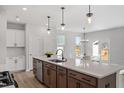 Bright kitchen features a large island with a sink, stylish pendant lights, and stainless steel appliances at 1004 Westerland Way # 197, Durham, NC 27703