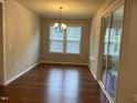 Bright dining room with hardwood floors, natural light, and sliding glass doors leading to patio at 1006 Pondfield Way, Durham, NC 27713
