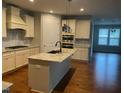 Bright kitchen features an island with granite countertops, stainless steel appliances, and ample cabinet space at 1006 Pondfield Way, Durham, NC 27713
