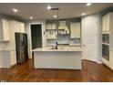 Well-designed kitchen with island, stainless steel appliances, granite countertops, and modern lighting at 1006 Pondfield Way, Durham, NC 27713
