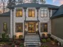Elegant two-story home featuring a stone facade, black framed windows, and a grand entrance at 1012 Casa Dega Way, Raleigh, NC 27613