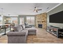 Comfortable living room with a stone fireplace, ceiling fan, and an adjacent dining area and kitchen at 106 Jared Ct, Graham, NC 27253