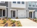 Close-up of a townhouse with a one-car garage, concrete driveway, and dark front door at 116 Central Townes Way # 293, Raleigh, NC 27603