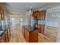 Modern kitchen with stainless steel appliances, dark countertops, wood cabinets, and island with pendant lighting at 1171 Jackson Ct, Creedmoor, NC 27522