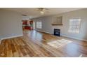 Bright living room featuring wood floors, a ceiling fan, a fireplace, and multiple windows for plenty of natural light at 1171 Jackson Ct, Creedmoor, NC 27522