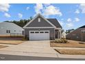 Quaint single-story home with a gray exterior, well-kept lawn, and a convenient two-car garage at 1254 White Flint Cir, Durham, NC 27703