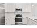 A close up view of kitchen appliances, including stainless steel range, microwave, and white cabinets at 1257 S Blount Street # 101, Raleigh, NC 27601