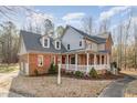 Spacious two-story home with brick and siding, featuring a large wrap-around porch at 1532 Rockwood Downs Dr, Wendell, NC 27591