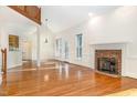 Open-concept living room with fireplace, hardwood floors, and ample natural light at 1532 Rockwood Downs Dr, Wendell, NC 27591