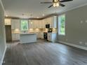 Bright kitchen featuring white cabinets, stainless steel appliances, pendant lighting, and beautiful wood floors at 162 Kirkwall Ln, Selma, NC 27576