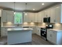 Modern kitchen with quartz countertops, white cabinetry, stainless appliances, and an island perfect for entertaining at 162 Kirkwall Ln, Selma, NC 27576