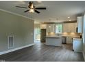 Open-concept kitchen flows seamlessly into the living area, featuring a ceiling fan and access to the outdoors at 162 Kirkwall Ln, Selma, NC 27576