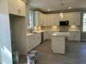 Modern kitchen featuring white cabinetry, stainless steel appliances, and a functional center island at 162 Kirkwall Ln, Selma, NC 27576