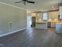 Open-concept living room showcasing gray wood-look flooring with views of the kitchen and sliding glass doors at 162 Kirkwall Ln, Selma, NC 27576