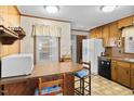 Eat-in kitchen area with wood cabinets, vintage countertops, and black appliances at 200 Barwick Way, Knightdale, NC 27545