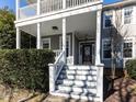 Inviting front porch with white pillars, steps leading to the door, and tasteful landscaping, ideal for relaxation at 2019 Falls River Ave, Raleigh, NC 27614
