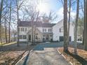 Beautiful two-story home with a gravel driveway, a black garage door, and decorative exterior trim at 2107 Spring Ln, Sanford, NC 27330