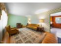 Inviting living room with vintage charm, showcasing floral wallpaper, hardwood floors, and classic furniture, offering a cozy space at 2311 Glover Rd, Durham, NC 27703