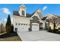 Exterior home featuring a two-car garage, stone accents, and manicured landscaping at 2505 Mt Zion Church Rd Rd, Apex, NC 27502