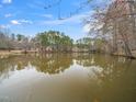 Scenic view of a tranquil lake reflecting trees under a blue sky with scattered clouds at 2639 Bowden Dr, Creedmoor, NC 27522