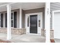 Close-up of a welcoming front entrance with stone accents and a black front door at 3016 Dog Rose Dr # 303, Durham, NC 27703