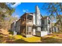 Rear of a building featuring a screened porch, outdoor seating, and a large chimney at 32 Melstone Turn, Durham, NC 27707