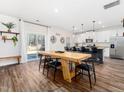 Open dining area featuring a long wooden table and kitchen island with modern bar stools at 325 Azalea Gaze Dr, Youngsville, NC 27596