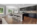 Modern kitchen featuring dark cabinets, stainless steel appliances, and a center island with seating at 3306 Leaflet Church Rd, Broadway, NC 27505