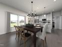 Bright dining room with hardwood floors, a modern chandelier, and views into the kitchen at 3715 Rosebush Dr, Zebulon, NC 27597