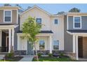 Charming two-story home with a modern farmhouse style and a tree in the front yard at 3717 Rosebush Dr, Zebulon, NC 27597