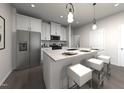Modern kitchen with stainless steel appliances, white cabinets, a center island with seating, and pendant lights at 3719 Rosebush Dr, Zebulon, NC 27597