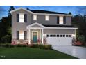 Beautiful two-story home with stone accents, a covered porch, manicured lawn and two car garage at 3825 Rosebush Dr, Zebulon, NC 27597