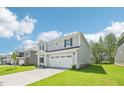 Charming two-story home featuring a well-maintained lawn and a two car garage at 3825 Rosebush Dr, Zebulon, NC 27597