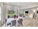 Bright dining area with contemporary table set, leading to living room and patio with scenic backyard view at 3829 Rosebush Dr, Zebulon, NC 27597