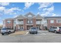 Apartment building with brick and siding, balconies, professional landscaping, and accessible parking at 411 Weather Ridge Ln # 45, Cary, NC 27513