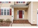 Inviting front entrance with a red door, sidelights, and brick steps at 515 Littleport Dr, Rolesville, NC 27571
