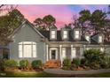Charming home featuring light-green clapboard siding, white trim, brick accents, and a landscaped front yard at 5413 Leopards Bane Ct, Holly Springs, NC 27540