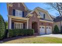 Attractive brick home featuring a two-car garage, landscaped yard, and classic architectural elements at 5712 Kirkwood Park Dr, Raleigh, NC 27612