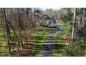 Aerial view of a home surrounded by trees with a long driveway in a natural setting at 65 Gentle Winds Dr, Chapel Hill, NC 27517