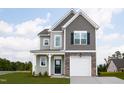 Inviting two-story home with stone accents, a charming front porch, and an attached garage offers modern living and curb appeal at 71 Furley St, Homesite 116, Sanford, NC 27330