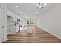 Bright, open kitchen with white cabinets, an island, stainless appliances, and wood floors at 803 Pryor St # 47, Mebane, NC 27302